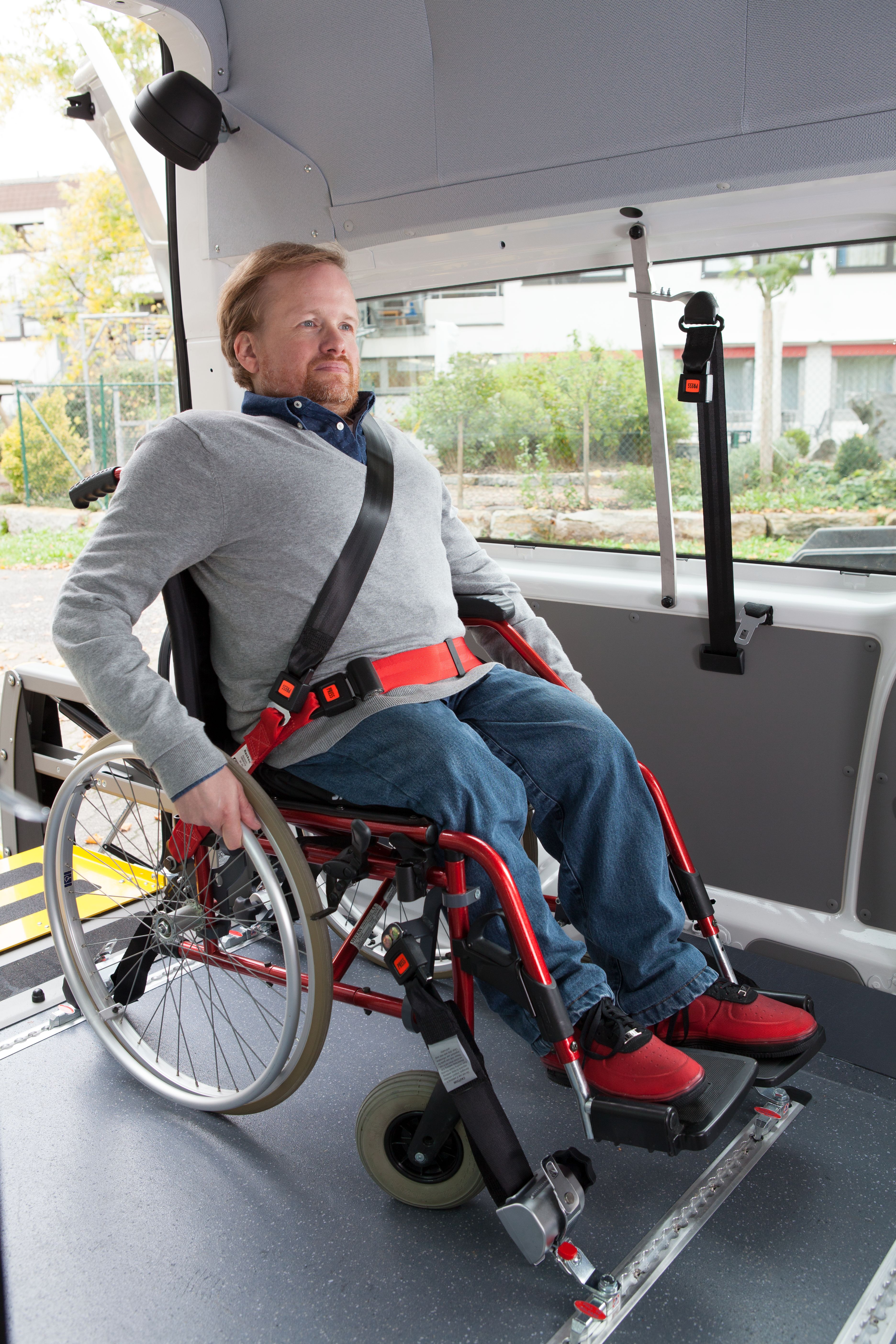 Rollstuhlnutzer rangiert in einem Transportfahrzeug.