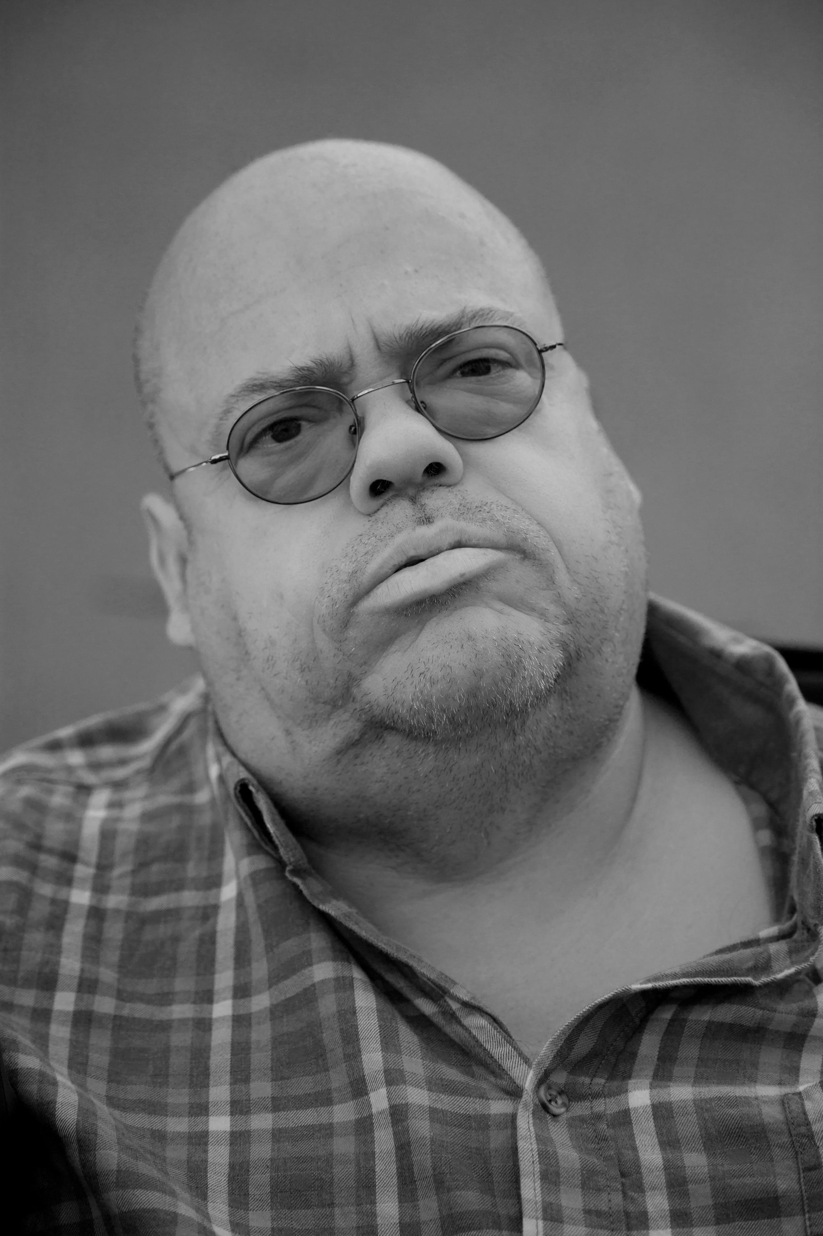 Porträt eines fülligen Mannes mit Brille.