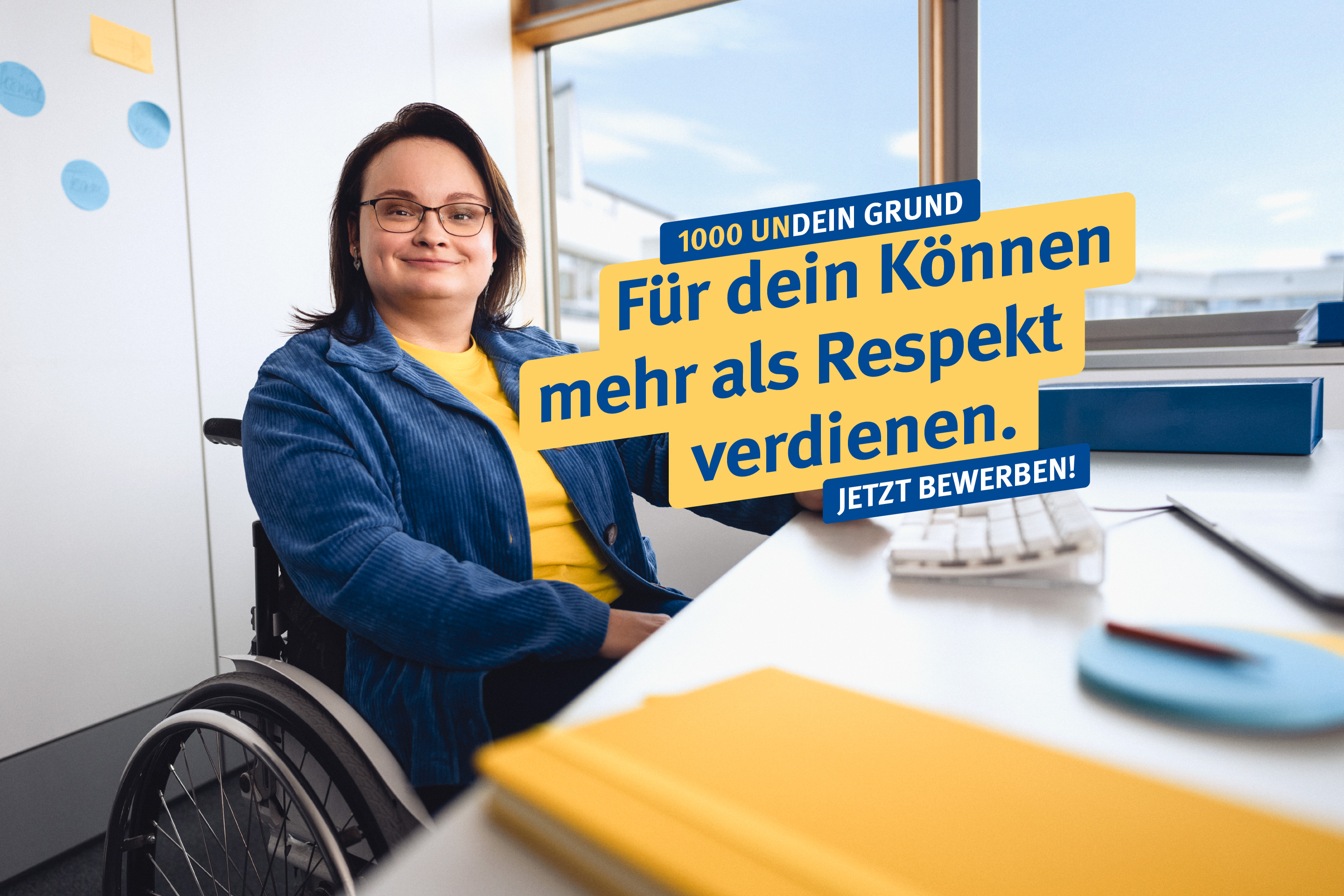 Eine Frau im Rollstuhl sitz am Schreibtisch, dazu der Text: "1000 undein Grund – Für dein Können mehr als Respekt verdienen. Jetzt bewerben"