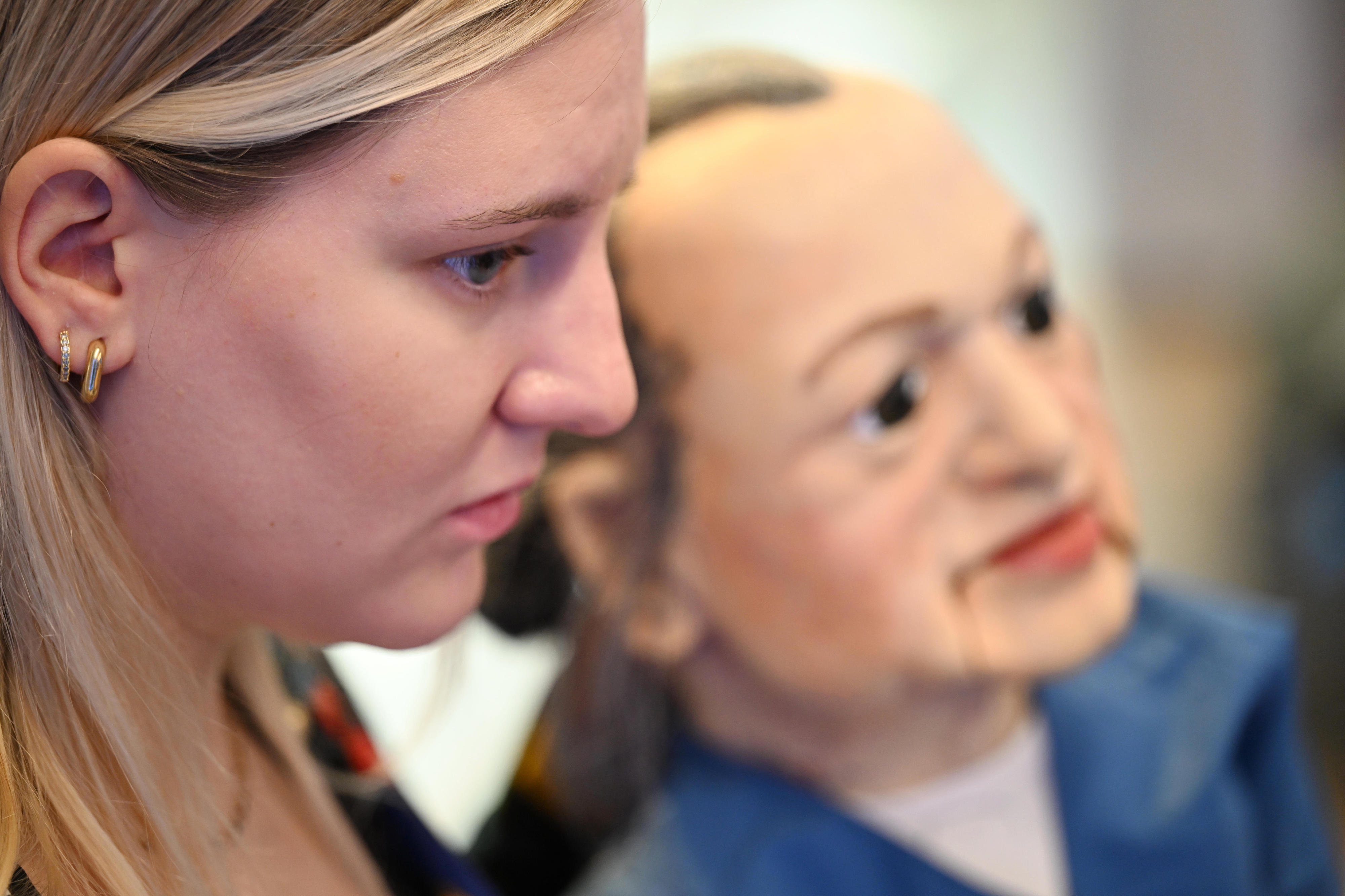 Das Gesicht einer Frau von der Seite und einer Holzpuppe