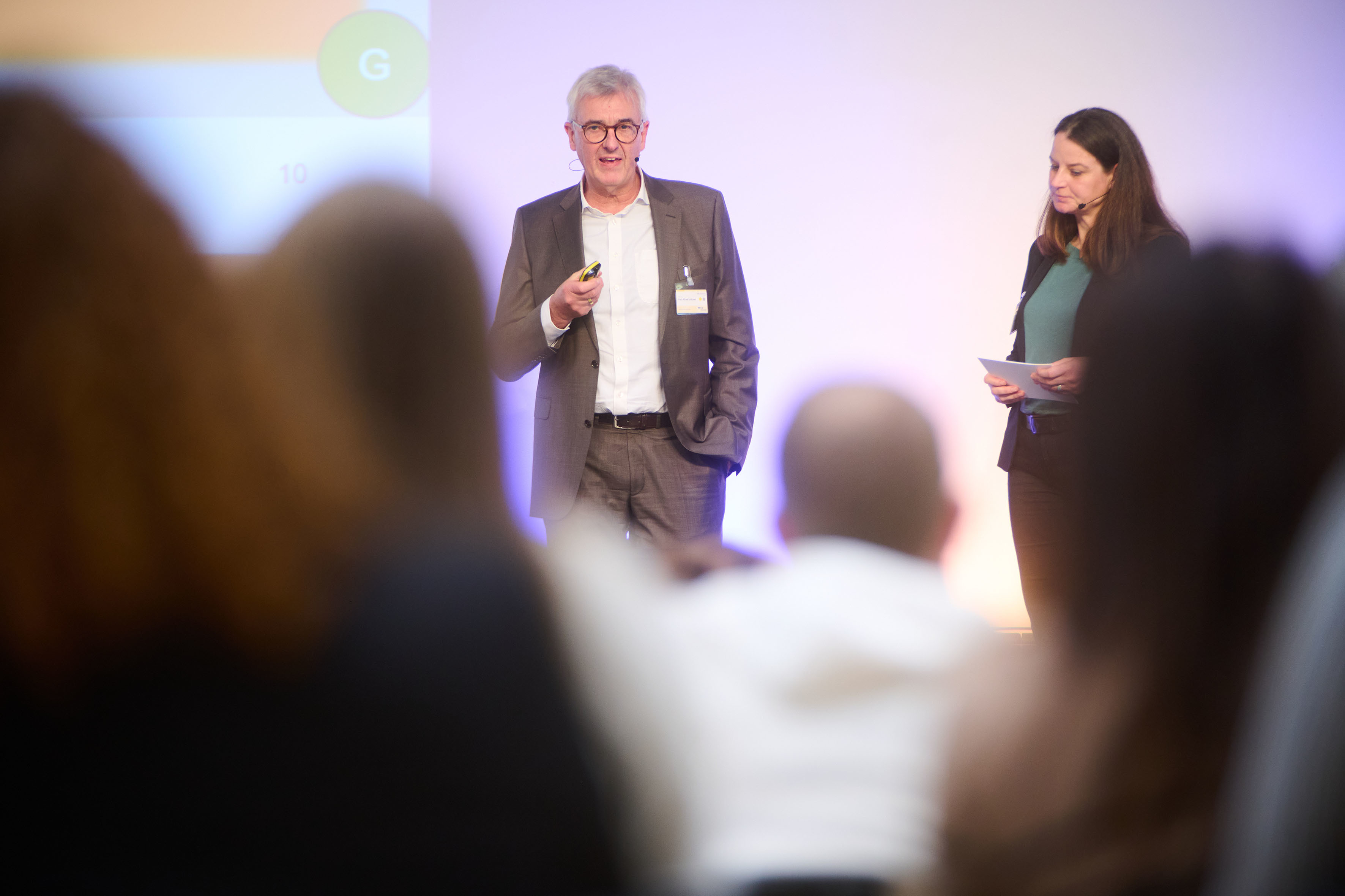 Blick aus dem Publikum auf Prof. Dr. Paul A. Grützner, Ärztlicher Direktor der BG Klinik Ludwigshafen, der auf der Bühne vorträgt.