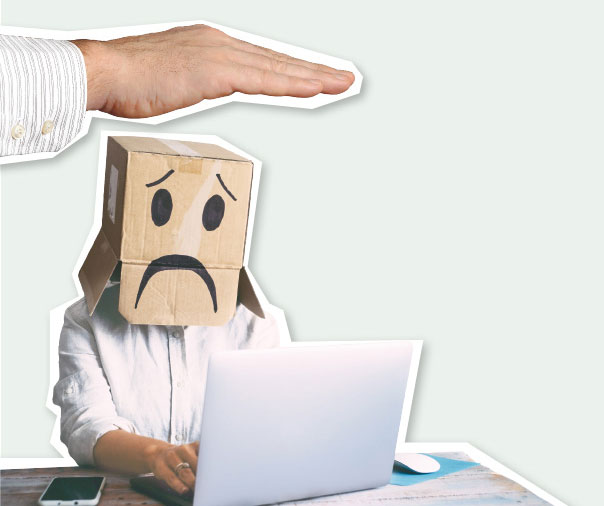 Collage: Eine große Hand schwebt über einer Person, die am Laptop arbeitet und einen Karton mit einem weinenden Smiley über den Kopf gestülpt hat.