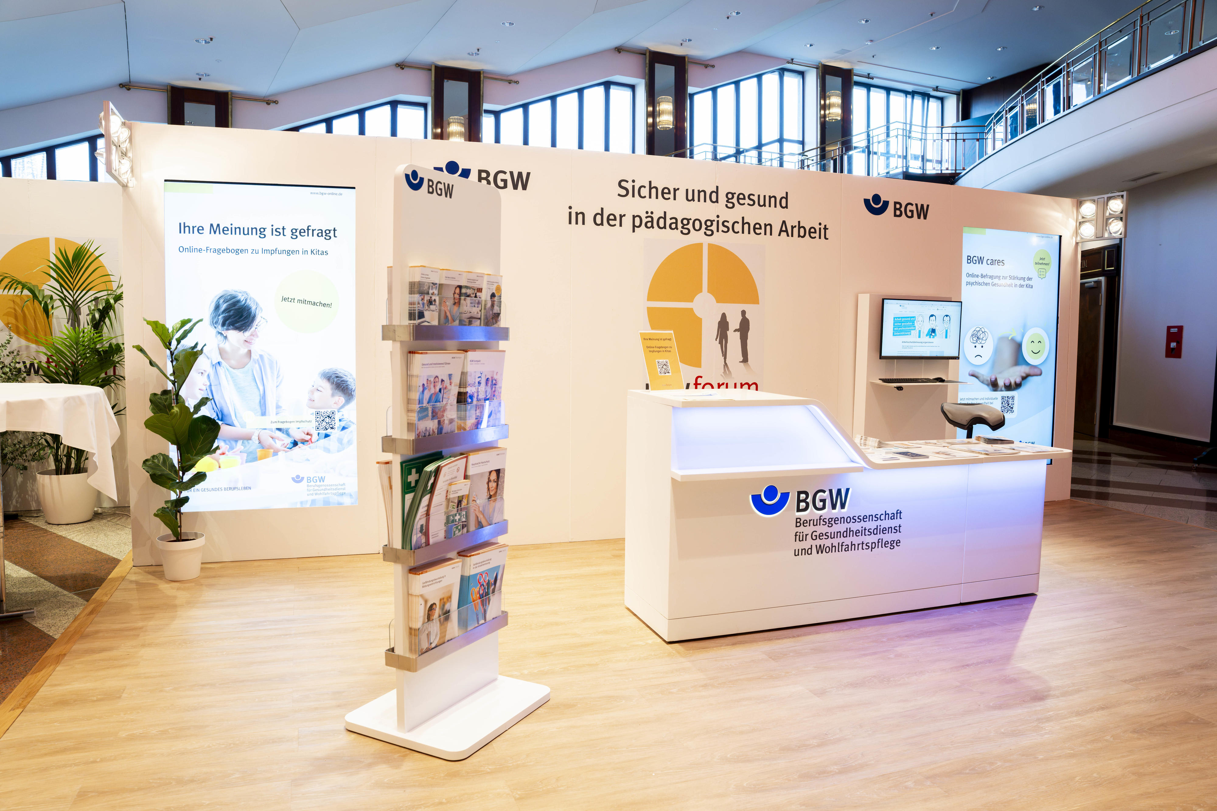 Hell beleuchteter Messestand mit Infotheke und Informationsmaterial anlässlich des BGW forum 2026 "Sicher und gesund in der Pädagogischen Arbeit"