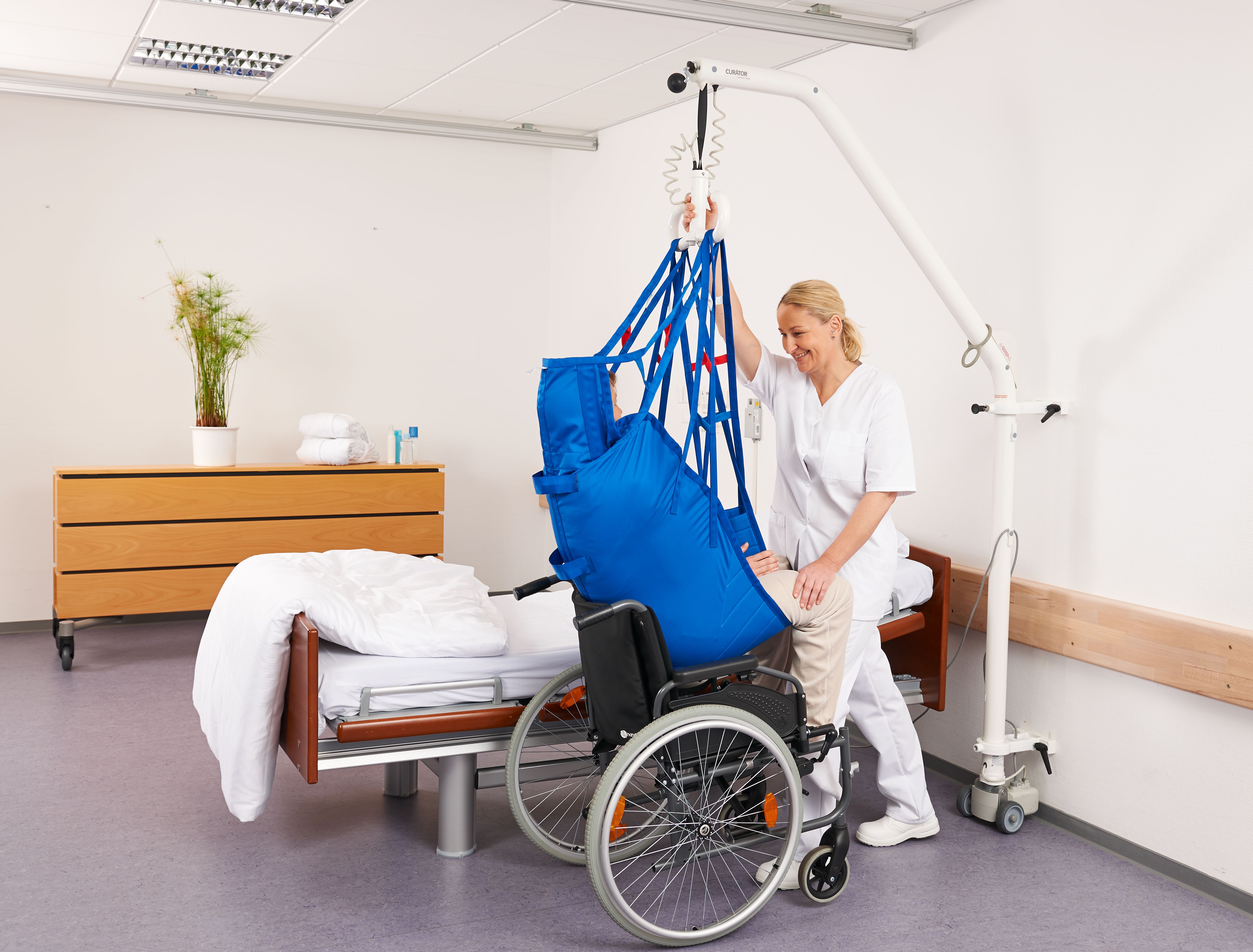 Pflegekraft beim Patiententransfer mit Wandlifter