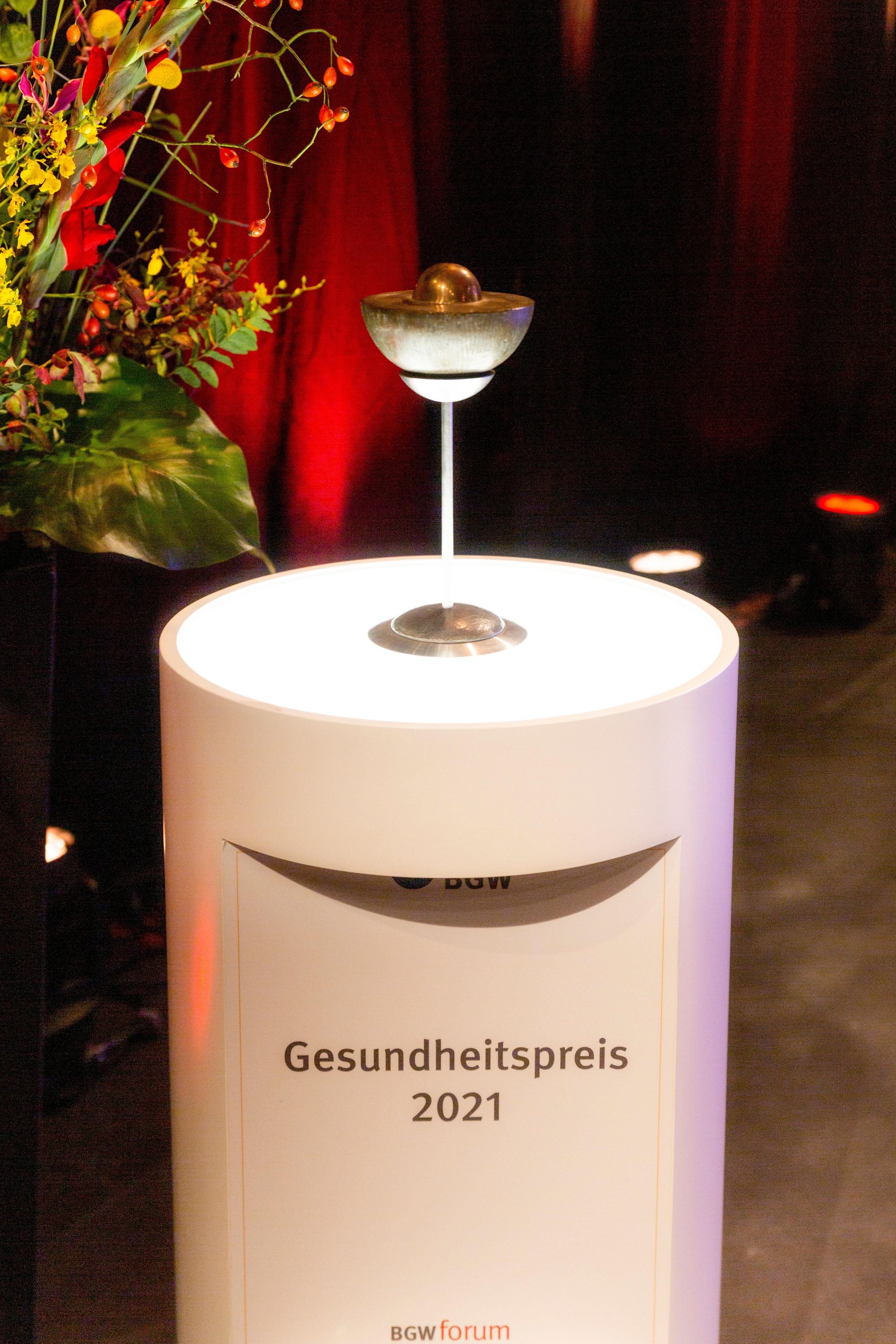 Pokal auf einer Säule mit Text "Gesundheitspreis 2021"