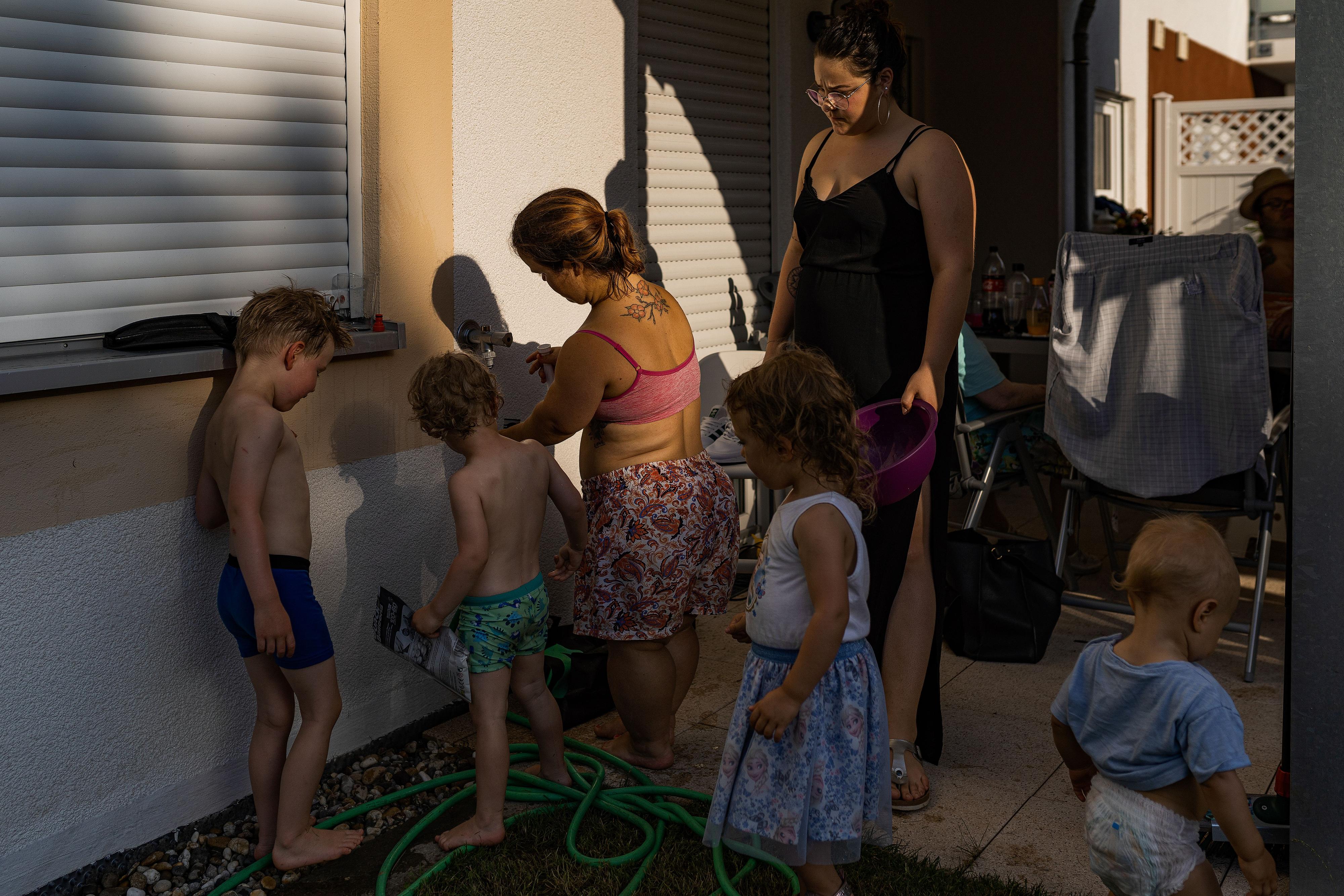 Mensch - Arbeit - Handicap 2021 Eine kleinwüchsige junge Frau füllt Wasserbomben auf der Terrasse. Links von ihr stehen zwei Jungen, hinter ihr ihr ein Mädchen und rechts eine weitere Frau.