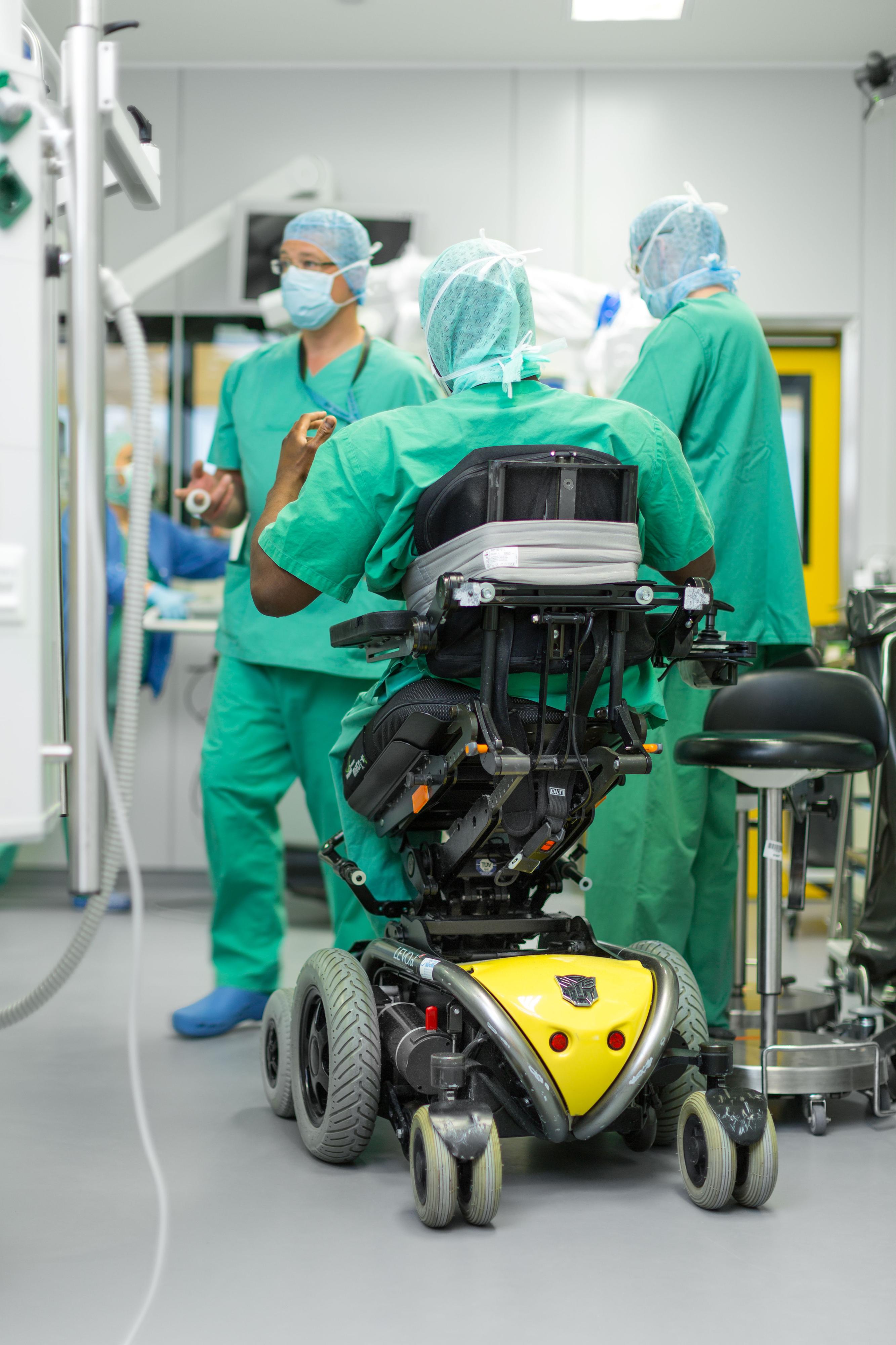 OP-Team im Krankenhaus - ein OP-Mitarbeiter sitzt in einem höhenverstellbaren Rollstuhl.
