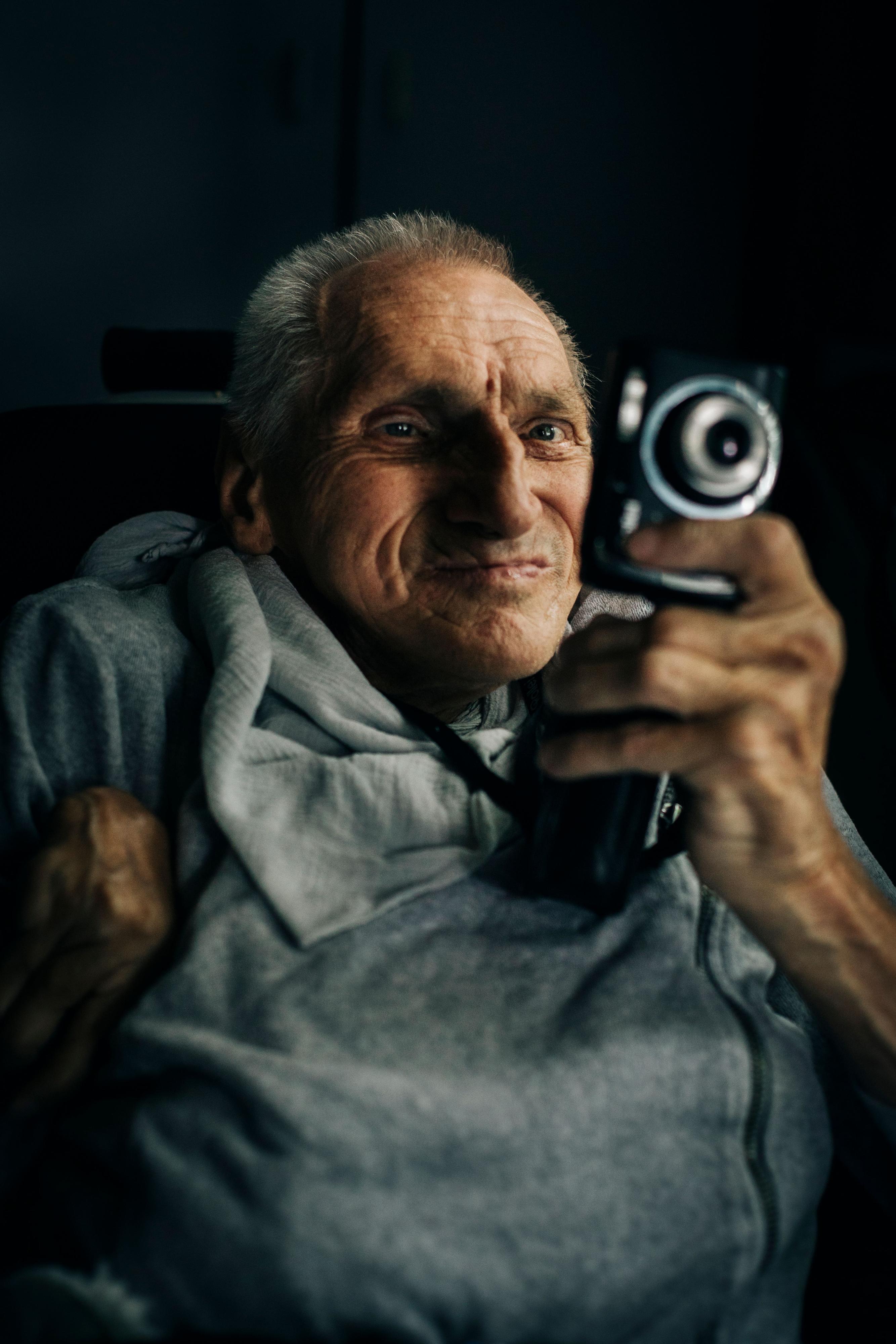 Ein alter Mann schaut durch den Sucher einer Kamera.