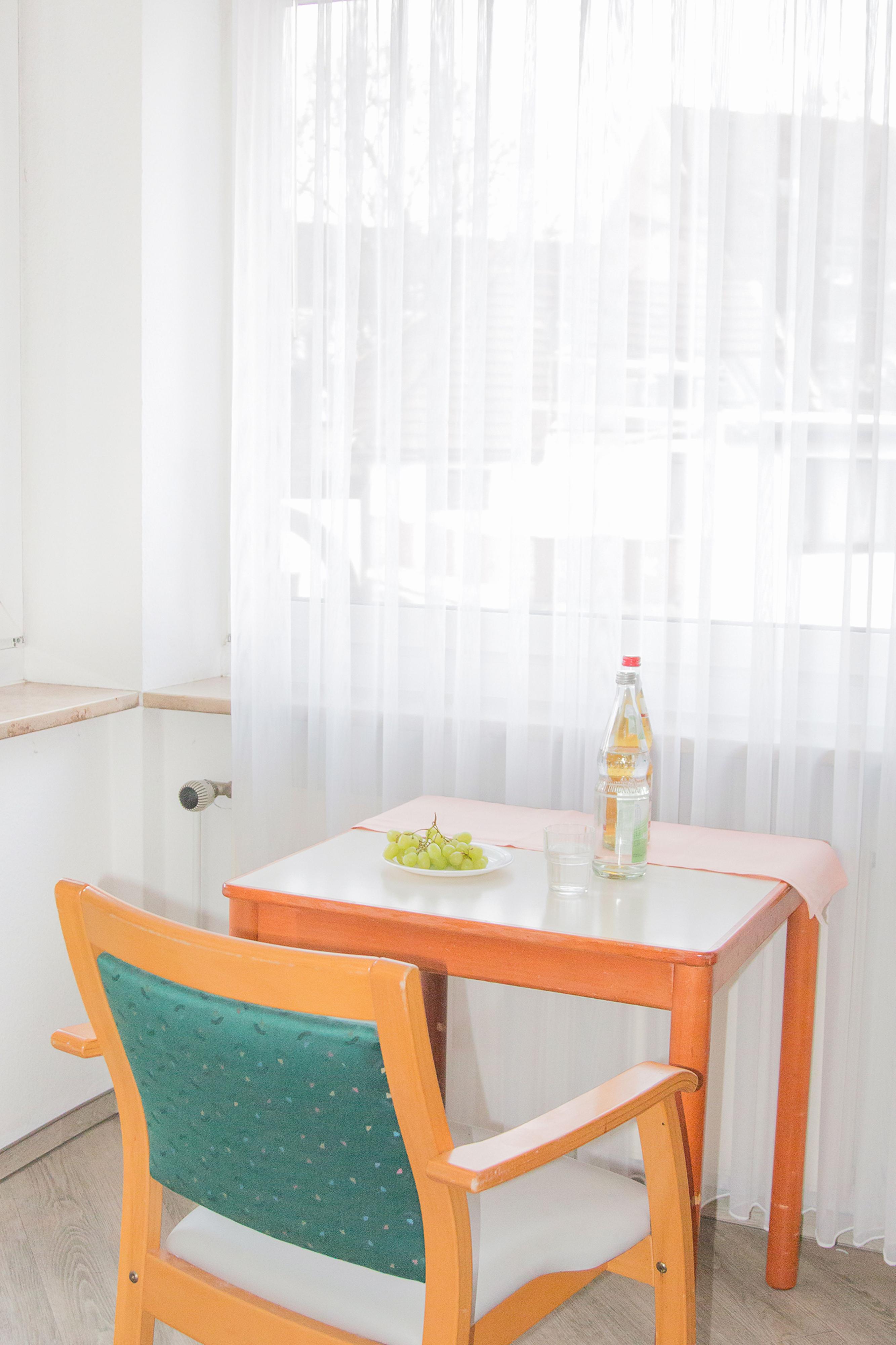 Eine Getränkeflasche und Weintrauben stehen auf einem Tisch im Pflegeheim.