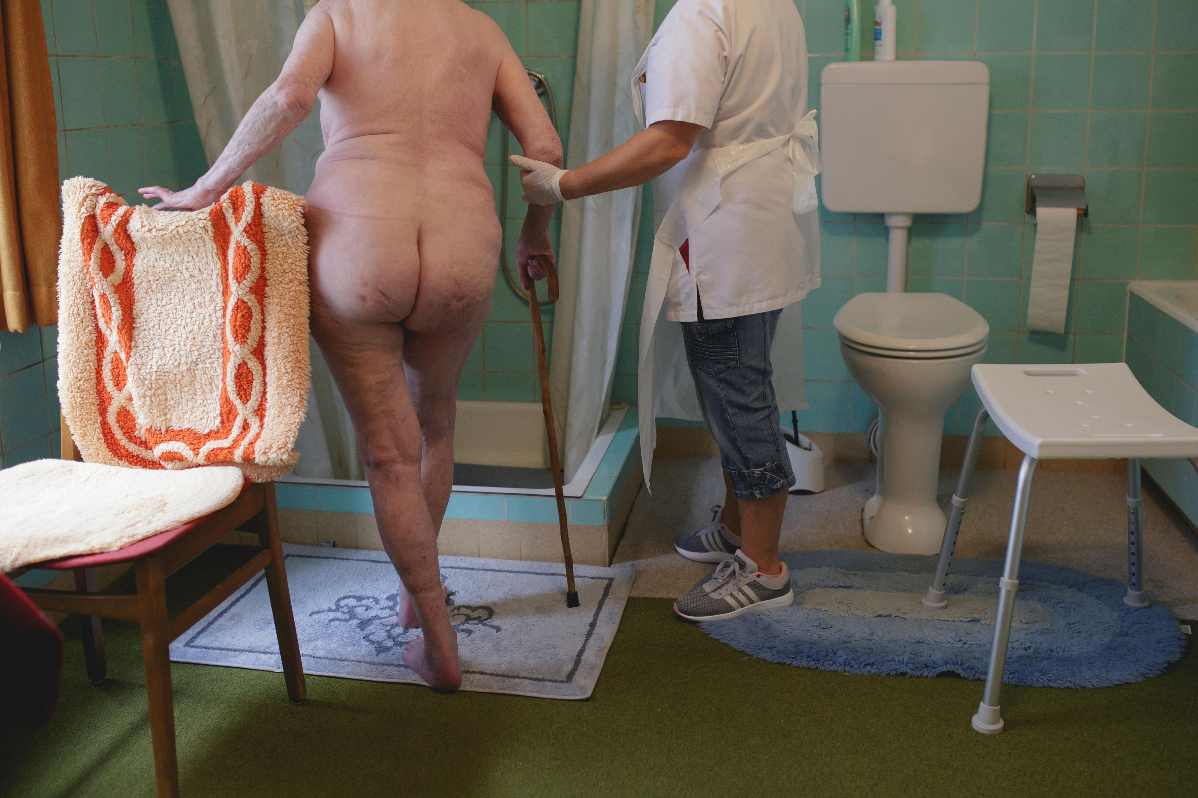 Mensch - Arbeit - Alter 2020 Eine Pflegerin hilft einer Frau in die Dusche.