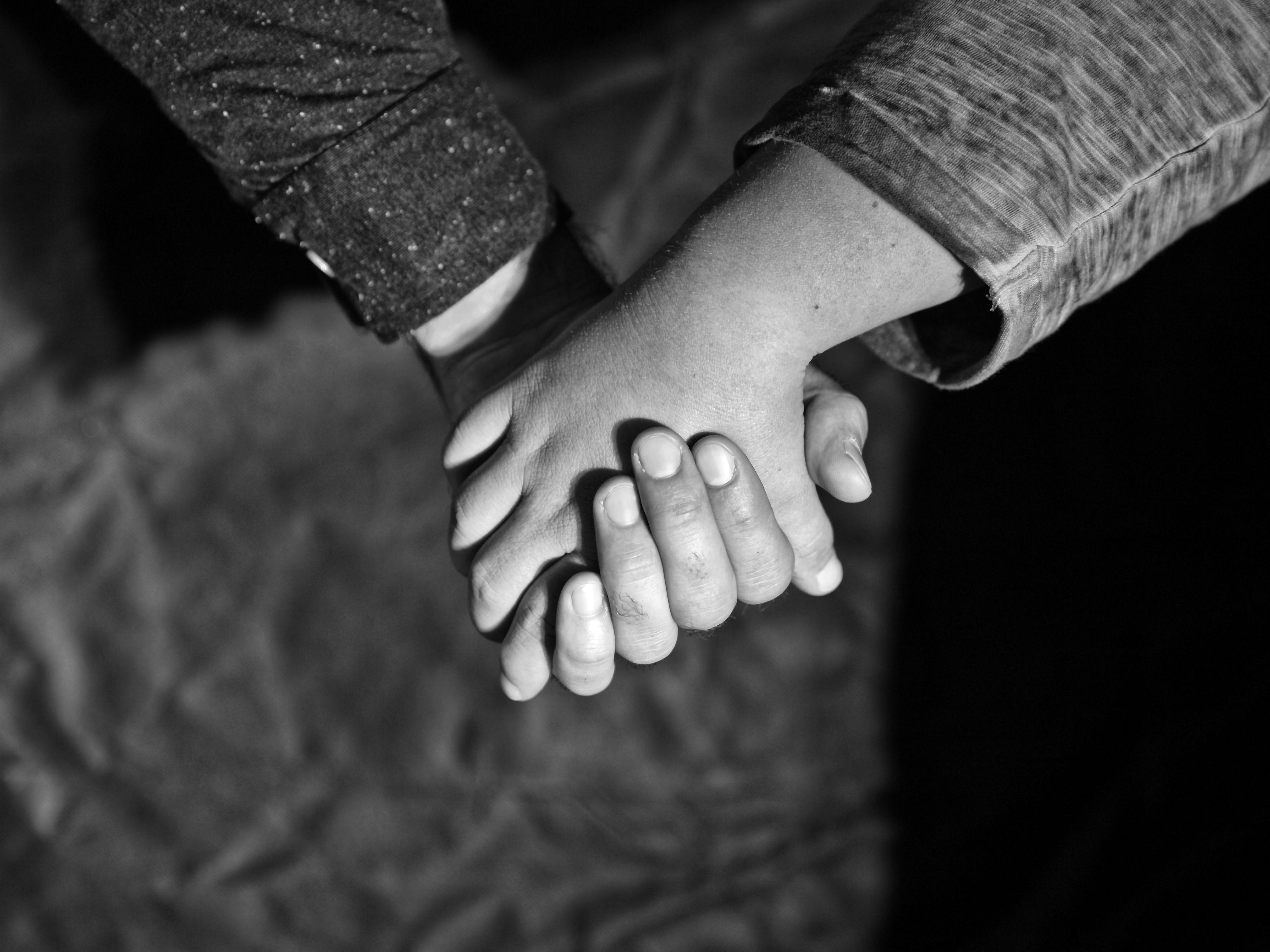 Zwei Hände halten sich gegenseitig.