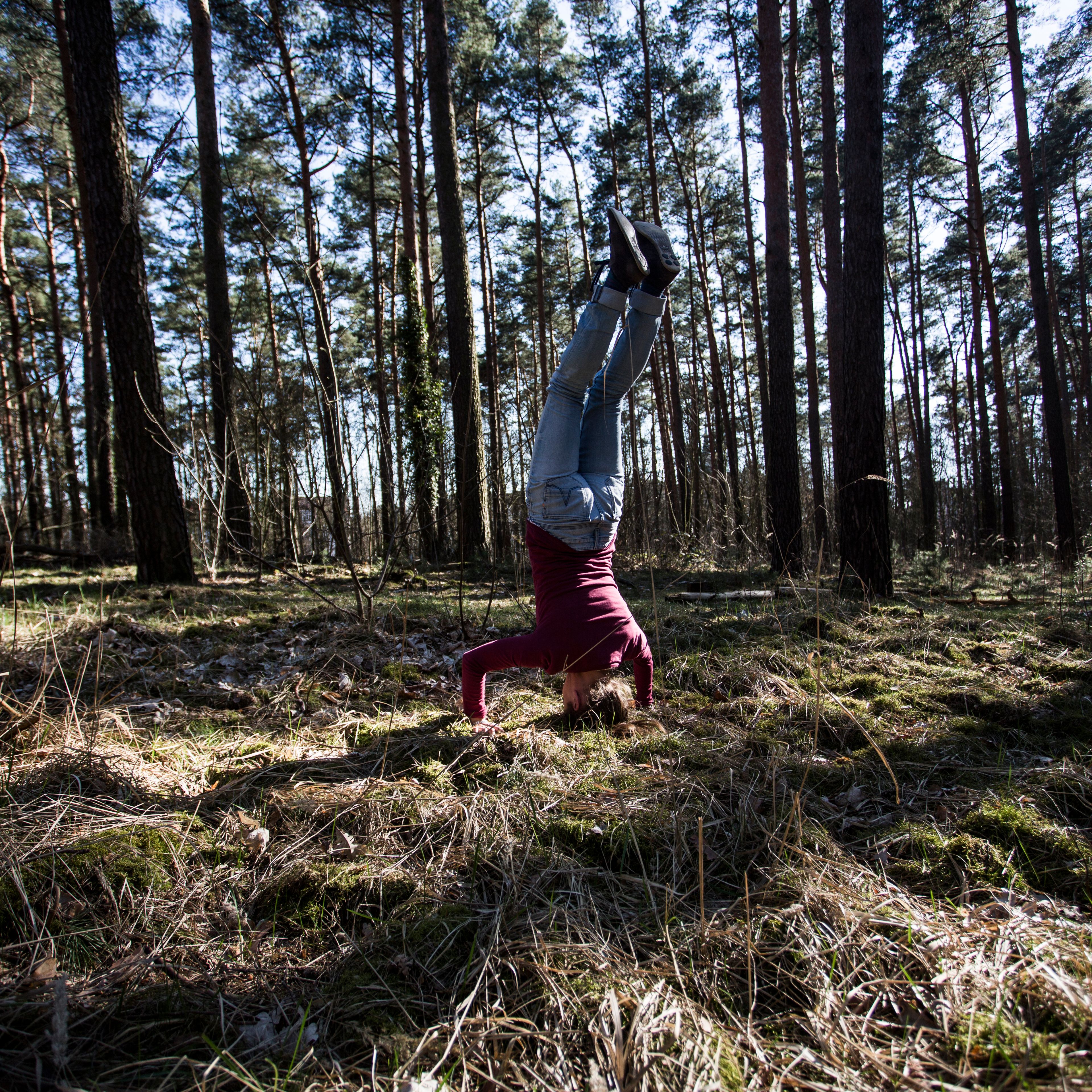 Mensch - Arbeit - Handicap 2017 Eine Frau macht einen Kopfstand im Wald.