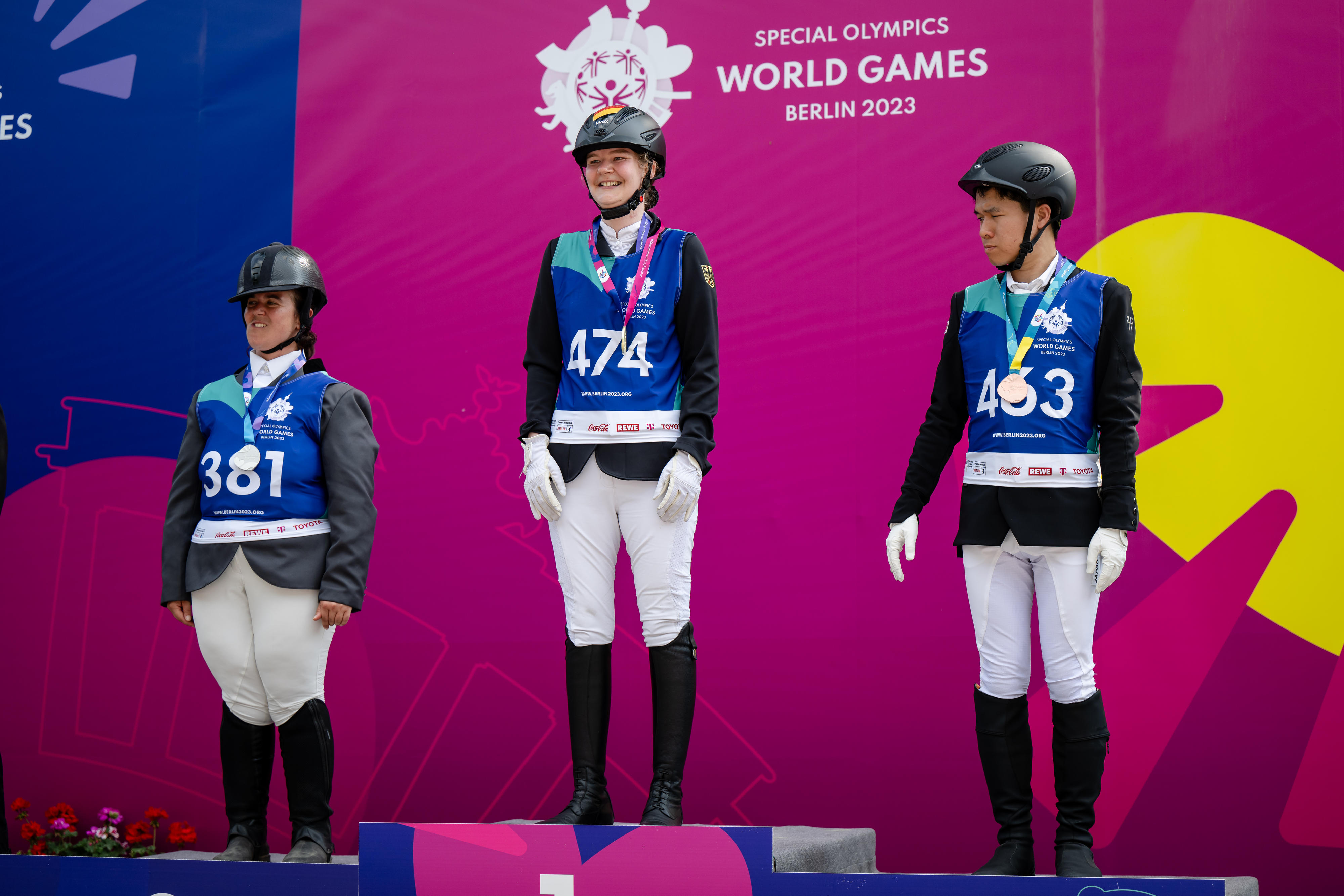 Lisa Preiss steht in der Mitte eines Siegertreppchens, links von ihr die Italienerin, rechts von ihr der Japaner.