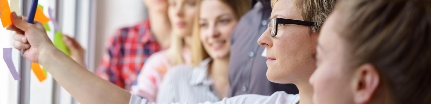 Workshop-Arbeit Team erarbeitet Ideen und klebt Zettel an ein Fenster
