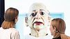 Überlebensgroße Puppe, der zwei Personen gegenüberstehen