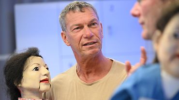 Eine Person mit Handpuppe im Gespräch mit einem Gegenüber mit Handpuppe
