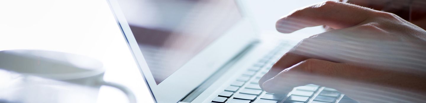 Hände auf einer Computer-Tastatur