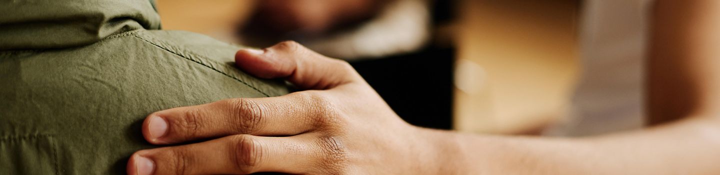Hand of young supportive man consoling his friend with post traumatic syndrome Hand of young supportive man consoling his friend or one of attendants with post traumatic syndrome caused by dramatic life event