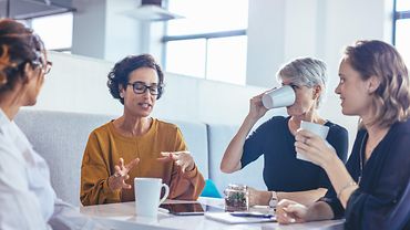 Aktives Zuhören Vier Personen sitzen an einem Tisch