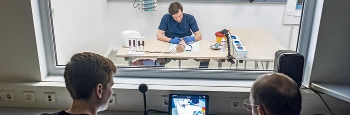 Laborsituation: Zwei Personen beobachten eine weitere Person bei der Durchführung eines Produkttests