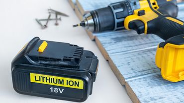 18 Volt Lithium Ion Akku und Akku-Schrauber Akkuschrauber, neben dem ein Lithium-Ion-Akku liegt