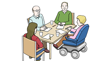 Eine Gruppe sitzt an einem Tisch und spricht miteinander.