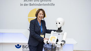 Eine Person neben einem Roboter.