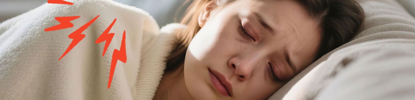 Frau auf Sofa mit dunklen Augenringen und in eine Decke eingewickelt. Rund um ihre Schulter sind rote Blitze