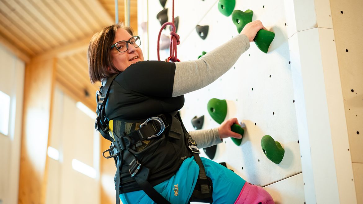 Eine Person klettert an der Kletterwand.