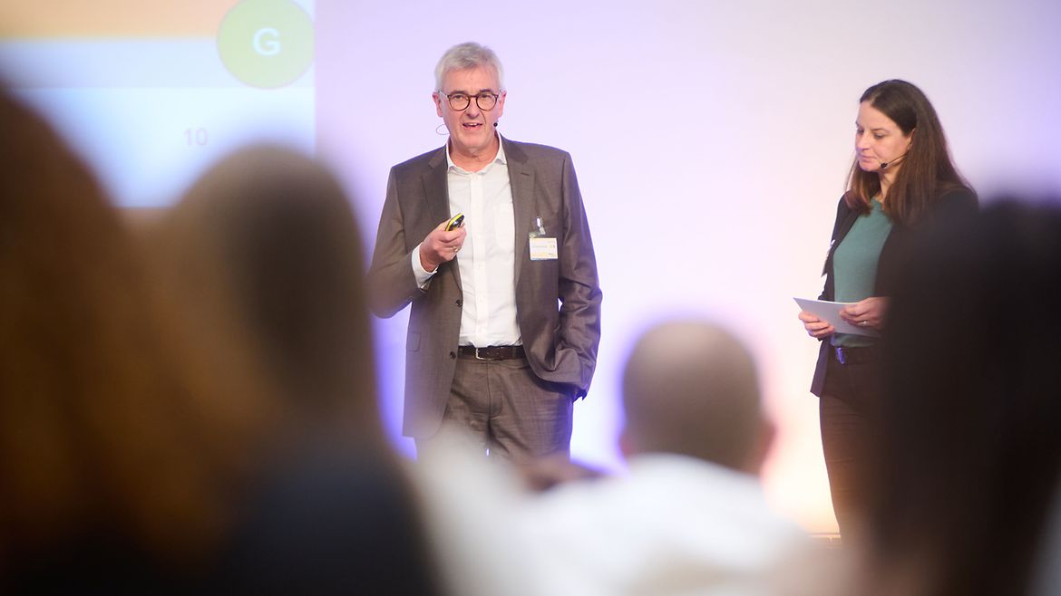 Blick aus dem Publikum auf Prof. Dr. Paul A. Grützner, Ärztlicher Direktor der BG Klinik Ludwigshafen, der auf der Bühne vorträgt.