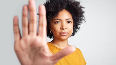 Eine junge Frau hält ihre ausgestreckte Hand der Kamera entgegen.