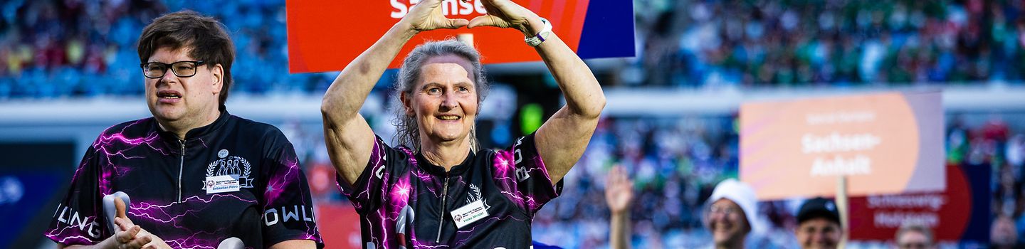 Teilnehmerin vom Team Sachsen läuft ins Stadion ein und formt mit den Händen ein Herz bei den Special Olympics Nationalen Sommerspielen 2026.