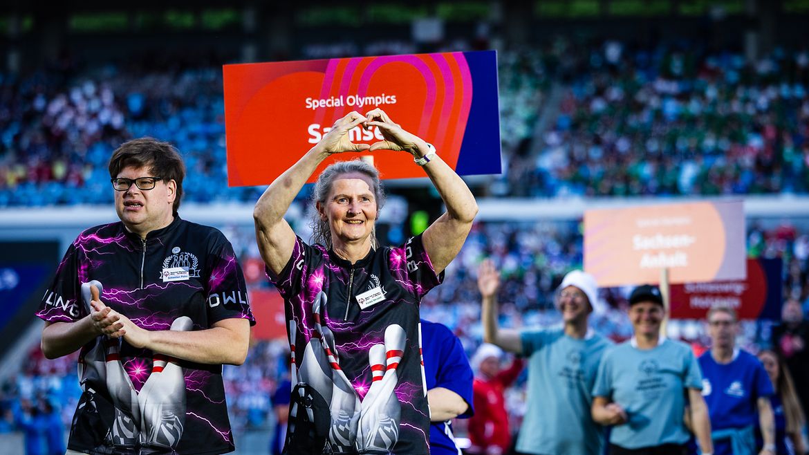 Teilnehmerin vom Team Sachsen läuft ins Stadion ein und formt mit den Händen ein Herz bei den Special Olympics Nationalen Sommerspielen 2026.