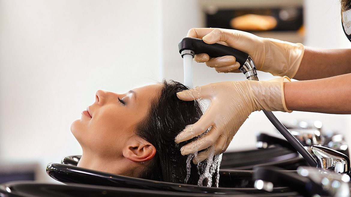 Einer Friseurkundin werden die Haare gewaschen