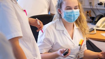 Schülerstation im BG Klinikum Hamburg Zwei Pflegeschülerinnen unterhalten sich im Dienstzimmer. Beide tragen einen Mund-Nasen-Schutz.