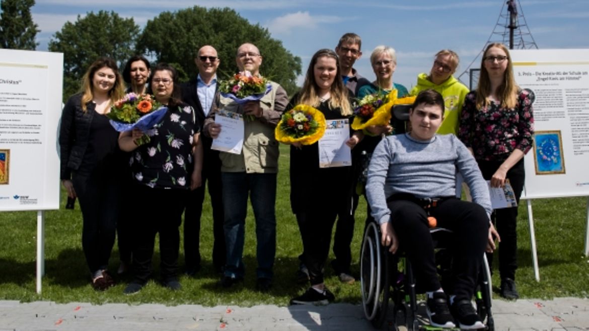 Alle ausgezeichneten Kunstschaffenden bei der Preisverleihung mit dem stellvertretendem Geschäftsführer der BGW, Jörg Schudmann, im Sonnenschein.