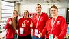 Zwei Frauen und zwei Männer, alle BGW-Volunteers und mit roten Hoodies bekleidet, stehen nebeneinander und zeigen gehobenene Daumen.