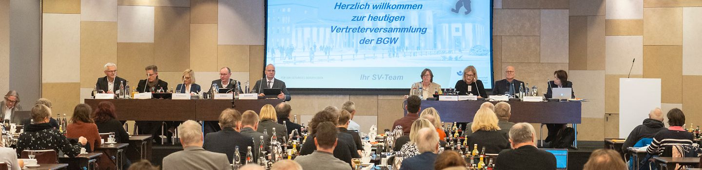 Selbstverwaltung tagt online Zwei Hände, die zusammen fünf verbundene Papierfiguren halten, die mittlere sitzt im Rollstuhl