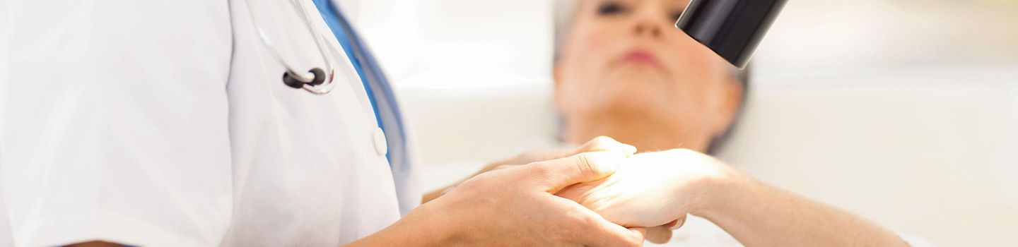 Dermatologin untersucht Patientenhand