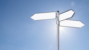 Leitlinien Dermatologie Ein Wegweiser mit drei in verschiedene Richtungen weisenden Schildern