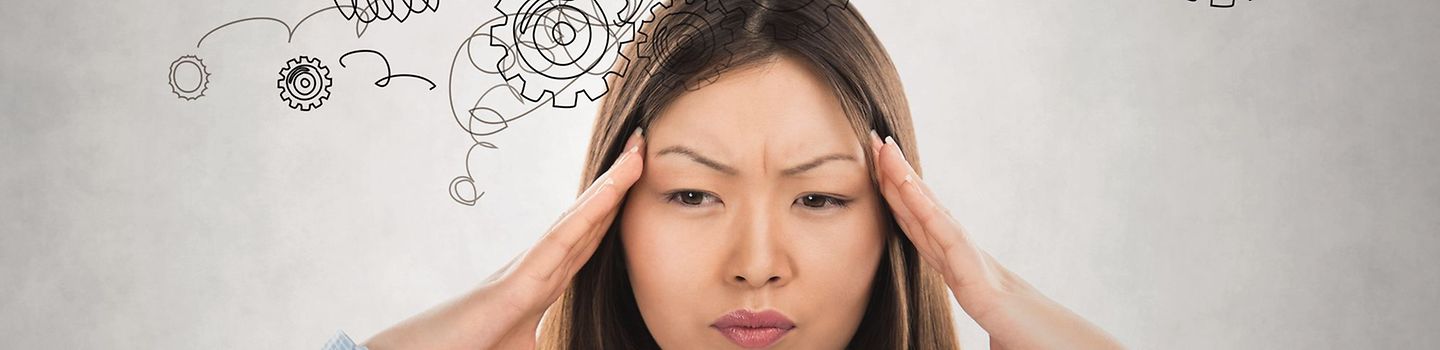 Junge Frau hält sich die Hände an beide Schläfen - im Hintergrund Stresssymbole als Illustration