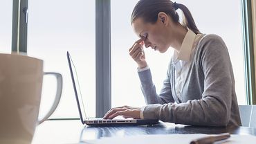 Psychische Belastungen Gestresste Frau am Laptop