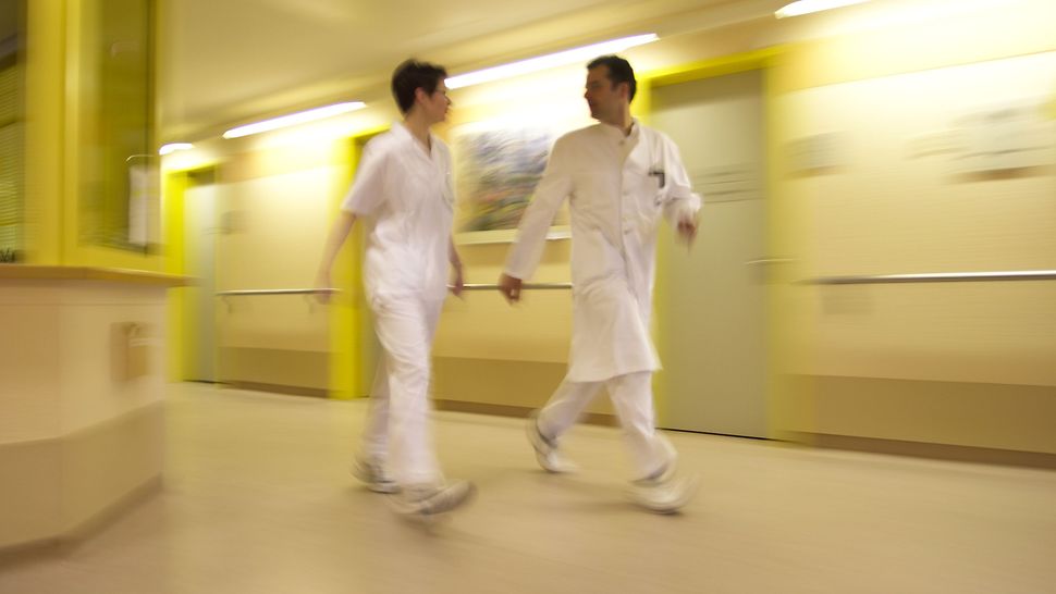 Stressbezogene Arbeitsanalyse für Klinikärztinnen und -ärzte – Mitarbeiterbefragung Ärzte laufen schnell den Krankenhausflur entlang
