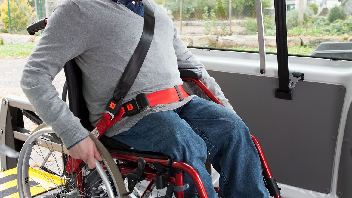 Rollstuhlnutzer rangiert in einem Transportfahrzeug.