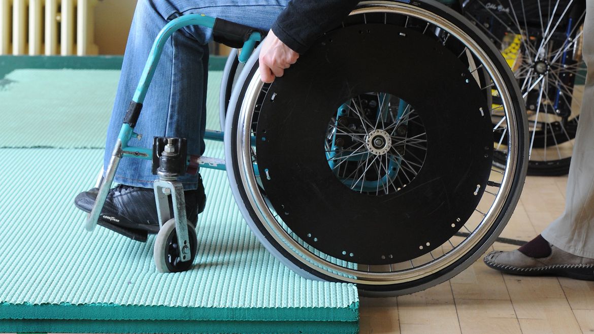 Frau trainiert in der Sporthalle das Überwinden von Kanten.