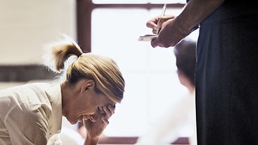 Frau erläutert nach Gewalterlebnis, was vorgefallen ist Frau sitzt verzweifelt vor einer anderen Person, die etwas aufschreibt.