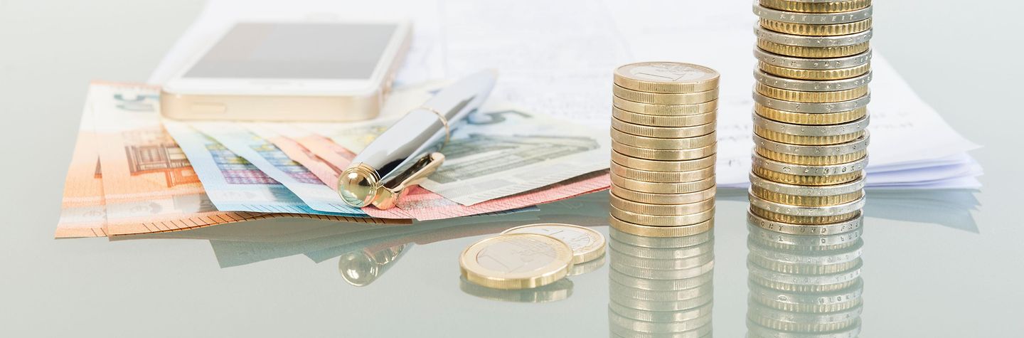 Geld Stapel Euromünzen, Geldscheine, Stift und Handy