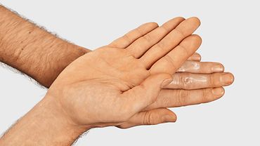 Creme wird Handrücken auf Handrücken verteilt.