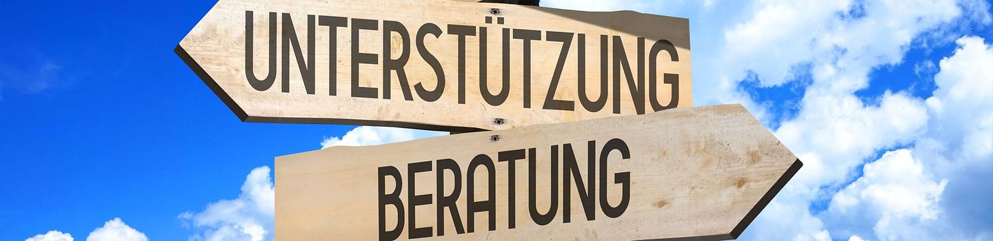 Vier hölzerne Wegweiser mit der Aufschrift: Hilfe, Unterstützung, Beratung und Führung
