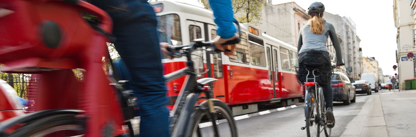 Straßenverkehr Verkehrssituation am Ende eines Radwegs. Radfahrer müssen sich in den fließenden Verkehr mit Autos und Straßenbahn einfädeln.